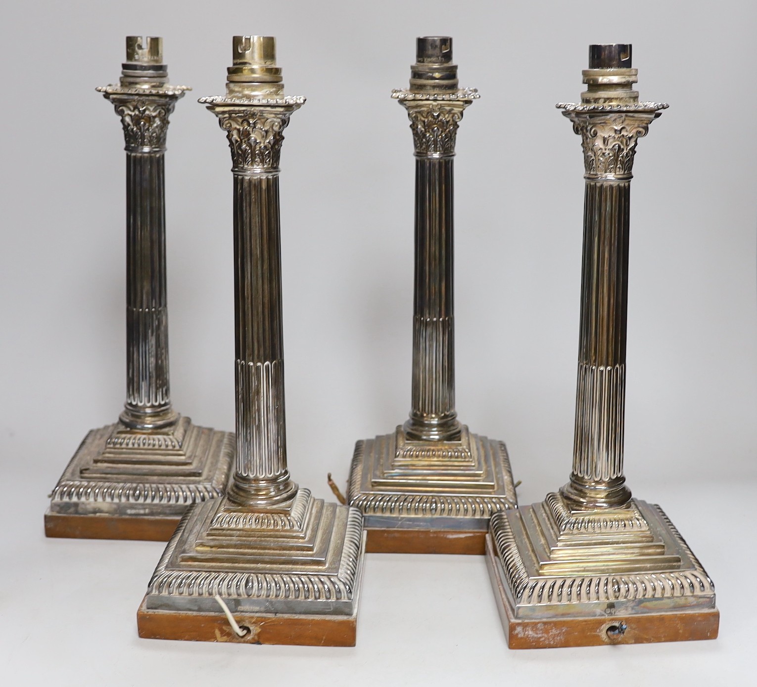 A set of four early 20th century silver plated Corinthian column table lamps on marble stands 33cms high (not including light fitting)